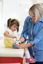 Doctor examining toy and little girl using stethoscope Royalty Free Stock Photo