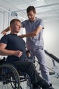 Doctor examining wheelchair patient shoulder pain. Checking posture Royalty Free Stock Photo