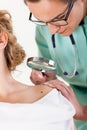 Doctor examining woman's mole