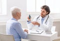 Doctor explaining pills schedule to senior patient