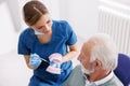 Doctor explaining procedure to patient on plastic jaw model at dentist office