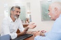 doctor explaining senior man how eye works Royalty Free Stock Photo