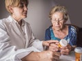 Doctor explains to elderly daily dose of medication