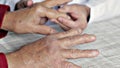 Doctor exploring the osteoarthritic hands of an elderly man