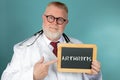Doctor holding Arthritis lettering chalkboard