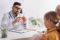 Doctor in eyeglasses pointing at jar