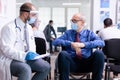 Doctor with face mask talking with disabled old man Royalty Free Stock Photo