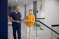 Doctor and female patient discussing something while standing in clinic corridor Royalty Free Stock Photo