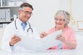 Doctor and female patient looking at reports in file Royalty Free Stock Photo