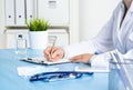 Doctor filling patient history list at clipboard
