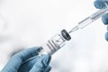 Doctor filling syringe with coronavirus vaccine on background, closeup