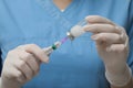 Doctor filling syringe with hepatitis vaccine from glass vial, closeup