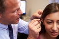 Doctor Fitting Female Patient With Hearing Aid