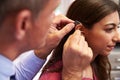 Doctor Fitting Female Patient With Hearing Aid