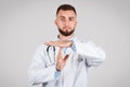 Doctor gesturing time-out, grey background Royalty Free Stock Photo