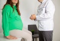 The doctor gives advice to a pregnant girl before giving birth in the doctor's office. Consultation of an obstetrician- Royalty Free Stock Photo