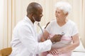 Doctor giving checkup with stethoscope to woman Royalty Free Stock Photo