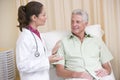 Doctor giving checkup to man in exam room Royalty Free Stock Photo