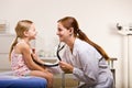 Doctor giving girl checkup in doctor office Royalty Free Stock Photo