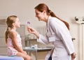 Doctor giving girl lollipop in doctor office