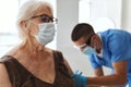 doctor giving an injection to an elderly woman patient covid passport Royalty Free Stock Photo