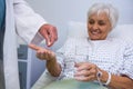 Doctor giving medicine pill to senior patient Royalty Free Stock Photo