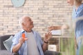 Doctor giving medicine to senior man at home Royalty Free Stock Photo
