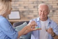 Doctor giving medicine to senior man at home Royalty Free Stock Photo