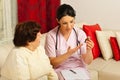 Doctor giving medicines to elderly woman