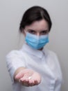 Doctor giving pills, woman in medical mask and gloves. The concept of the dose of drugs, vitamins, medical examination,