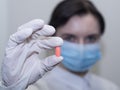 Doctor giving pills, woman in medical mask and gloves. The concept of the dose of drugs, vitamins, medical examination, Royalty Free Stock Photo