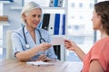 Doctor giving a prescription to her patient in medical office Royalty Free Stock Photo