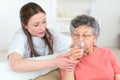 Doctor giving sick senior woman glass water Royalty Free Stock Photo
