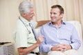 Doctor giving smiling man checkup Royalty Free Stock Photo