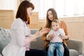 Doctor giving a spoon of syrup to little kid girl Royalty Free Stock Photo