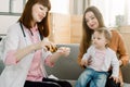 Doctor giving a spoon of syrup to little kid girl Royalty Free Stock Photo