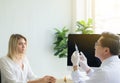 Doctor giving vaccine to woman patient with injection or syringe in hospital room Royalty Free Stock Photo