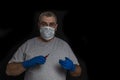 a doctor with glasses and a disposable mask and disposable gloves holds a syringe with red liquid Royalty Free Stock Photo