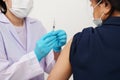 doctor holding syringe and making injection to patient in medical mask. Covid-19 or coronavirus vaccine Royalty Free Stock Photo