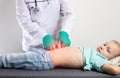 A doctor in green medical gloves is palpating the abdomen of a little seven-year-old girl. Stomach disease, gastritis Royalty Free Stock Photo