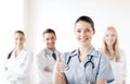 Doctor with group of medics showing thumbs up