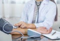 Doctor hand examines the patient's pulse with stethoscope and records the results, health medical checkup concept Royalty Free Stock Photo