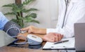 Doctor hand examines the patient's pulse with stethoscope and records the results, health medical checkup concept Royalty Free Stock Photo