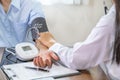 Doctor hand examines the patient's pulse with stethoscope and records the results, health medical checkup concept Royalty Free Stock Photo