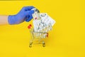 Doctor hand in gloves put bottle with capsule to shopping cart with medicine pills isolated. online order pharmacy delivery. safe