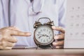 Doctor hand holding alarm clock showing the time ,can be used for appointment