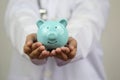 Doctor hand holding blue piggy bank on white background, Health insurance concept Royalty Free Stock Photo