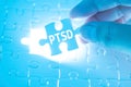 Doctor hand holding a jigsaw puzzle with PTSD - post traumatic s Royalty Free Stock Photo