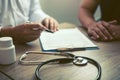 Doctor hand holding pen and talking to the patient about medication and treatment