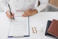 Doctor hand holding pen writing patient history list on note pad and talking to the patient about medication and treatment Royalty Free Stock Photo